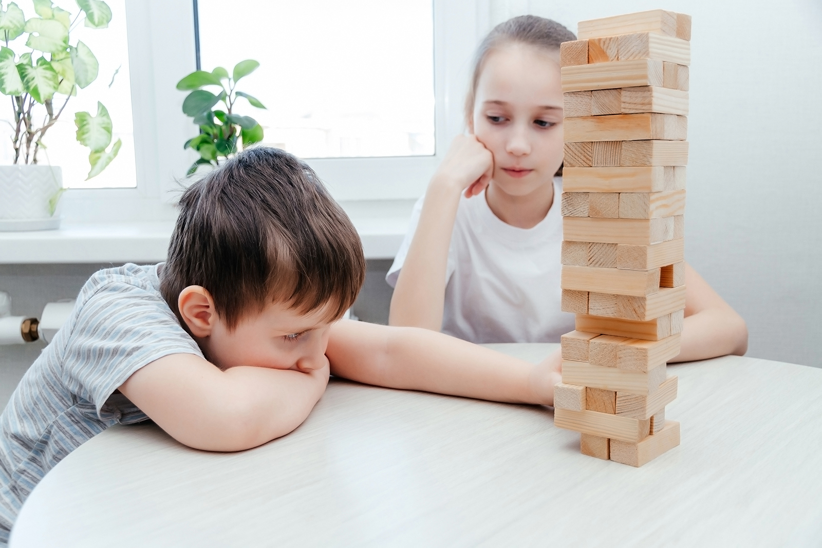 Caucasian children, boy and girl playing jenga. Block stacking game