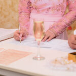 Groom and bride sign marriage documents at registry office, by official atmosphere. Romantic moment Newlyweds officially register their union during civil ceremony at wedding registry.